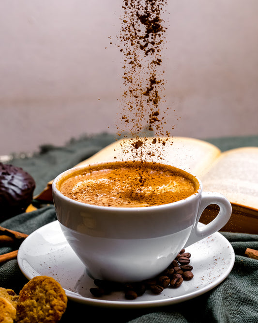 Impression d'art sur le café | Latte saupoudré de cannelle avec livre et biscuits
